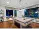 Bright game room features a modern-style pool table, recessed lighting, and access to the outdoor pool area at 48 Grande Fairway, Englewood, FL 34223