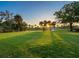 Beautiful golf course view, featuring mature trees and a lake in the background at 48 Grande Fairway, Englewood, FL 34223