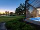Sunset view of the manicured golf course from the screened-in patio and yard at 48 Grande Fairway, Englewood, FL 34223