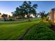 Beautiful golf course view at sunset, with mature trees and manicured green lawn at 48 Grande Fairway, Englewood, FL 34223