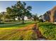 Beautiful golf course view at sunset, featuring mature trees, walking path and lush green lawn at 48 Grande Fairway, Englewood, FL 34223