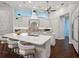 Bright, modern kitchen with white cabinets, stainless steel appliances, and a large center island at 48 Grande Fairway, Englewood, FL 34223