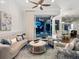 Bright living room with a ceiling fan, plush seating, and sliding glass doors to the outdoor area at 48 Grande Fairway, Englewood, FL 34223