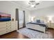 Bedroom with wood floors, a ceiling fan, dresser with a television and large window at 48 Grande Fairway, Englewood, FL 34223