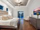 Elegant main bedroom featuring tray ceilings, wood floors, and a view to the pool and lanai at 48 Grande Fairway, Englewood, FL 34223