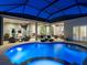Screened-in pool with lights, an outdoor kitchen, ample seating, and covered patios at 48 Grande Fairway, Englewood, FL 34223