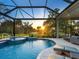 The enclosed pool offers a view of a golf course and is completed with a jacuzzi and lounge chairs at 48 Grande Fairway, Englewood, FL 34223