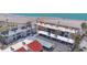 Aerial view showcasing condo buildings with parking, palm trees, and beach access at 500 Park S Blvd # 62, Venice, FL 34285