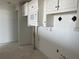 Kitchen with microwave and upper white cabinets and black diamond backsplash and exposed concrete floors at 500 Park S Blvd # 62, Venice, FL 34285