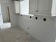 Galley kitchen with white cabinets, black diamond backsplash and exposed concrete floors at 500 Park S Blvd # 62, Venice, FL 34285