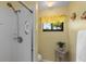 Tile shower with a window in a bathroom featuring neutral walls and floors at 500 Wekiva River Ct # 129, Englewood, FL 34223