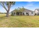Sprawling single-story home showcasing mature landscaping, palm trees, and a lush green lawn at 500 Wekiva River Ct # 129, Englewood, FL 34223