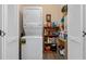 Efficient laundry room featuring a stacked washer and dryer and shelving with cleaning supplies at 500 Wekiva River Ct # 129, Englewood, FL 34223