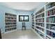 Bright library features floor-to-ceiling bookshelves and a cozy reading nook with a tranquil outdoor view at 500 Wekiva River Ct # 129, Englewood, FL 34223
