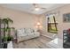 Relaxing sitting room featuring wood-look floors, a comfortable sofa, and serene natural light at 500 Wekiva River Ct # 129, Englewood, FL 34223