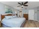 Spacious main bedroom featuring wood-look floors, a ceiling fan, and ample closet space at 500 Wekiva River Ct # 129, Englewood, FL 34223
