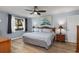 Light filled main bedroom with a ceiling fan, wood-look floors, and a serene atmosphere at 500 Wekiva River Ct # 129, Englewood, FL 34223