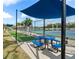 Pickleball court featuring a covered picnic table, lighting, and a view of adjacent tennis courts at 500 Wekiva River Ct # 129, Englewood, FL 34223
