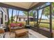 Relaxing screened-in porch with wicker furniture, offering a tranquil outdoor living space with views of the yard at 500 Wekiva River Ct # 129, Englewood, FL 34223