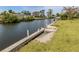 Concrete dock with pylons and a boat slip leading out to open water at 504 Buena Vista Dr, Nokomis, FL 34275