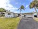 Charming single-story home with palm trees, a garage and a paved driveway at 504 Buena Vista Dr, Nokomis, FL 34275