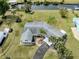 Aerial view of single-story home with driveway, palm trees and well-maintained lawn at 504 Buena Vista Dr, Nokomis, FL 34275