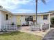 Charming front entrance with yellow door and shutters, surrounded by lush landscaping at 504 Buena Vista Dr, Nokomis, FL 34275