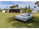 Boat on lawn next to house with screened patio, bird bath, and lush plants at 504 Buena Vista Dr, Nokomis, FL 34275