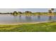 Picturesque view of a serene lake with lush green shoreline, creating a peaceful backyard oasis at 5223 Pine Shadow Ln, North Port, FL 34287