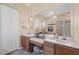 A large bathroom with dual sinks, vanity seating, and a private shower at 5223 Pine Shadow Ln, North Port, FL 34287