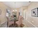 Formal dining room with chandelier and glass table provides a perfect space for Gathering meals and entertaining guests at 5223 Pine Shadow Ln, North Port, FL 34287