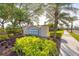 Elegant entrance sign for Pine Meadows community, complemented by manicured bushes and mature trees at 5223 Pine Shadow Ln, North Port, FL 34287