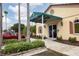 The fitness center entrance has a green awning and manicured landscaping at 5223 Pine Shadow Ln, North Port, FL 34287