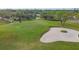 Aerial shot of a pristine golf course with lush greens, a sand trap, and manicured landscaping at 5223 Pine Shadow Ln, North Port, FL 34287