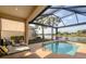 Inviting in-ground pool, screened in lanai, with lake views and mature landscaping at 5223 Pine Shadow Ln, North Port, FL 34287