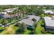 Aerial shot of the property with a well-manicured lawn, palm trees, and screened lanai at 525 Cheval Dr, Venice, FL 34292