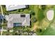 Aerial view of home featuring tile roof, solar panels, screened-in pool, and golf course at 525 Cheval Dr, Venice, FL 34292