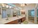 Bathroom featuring a double sink vanity, decorative wallpaper, and a large mirror at 525 Cheval Dr, Venice, FL 34292