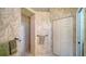 Bathroom showcasing a walk-in shower, wallpaper with a foliage pattern, and a towel rack at 525 Cheval Dr, Venice, FL 34292