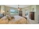 A bedroom with a patterned bedspread, ceiling fan, and large window overlooking a yard at 525 Cheval Dr, Venice, FL 34292