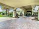 Grand entrance featuring a porte cochere, brick pavers, and colorful landscaping for a welcoming arrival experience at 525 Cheval Dr, Venice, FL 34292