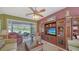 Cozy living room features comfortable seating, a ceiling fan, and a large entertainment center at 525 Cheval Dr, Venice, FL 34292
