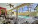 Relaxing screened-in lanai featuring a private pool, comfortable seating, and lush tropical landscaping at 525 Cheval Dr, Venice, FL 34292