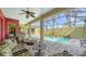 Relaxing screened-in lanai featuring a private pool, comfortable seating, and lush tropical landscaping at 525 Cheval Dr, Venice, FL 34292
