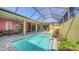 Inviting screened-in pool area with a sparkling pool, patio, and beautifully landscaped garden at 525 Cheval Dr, Venice, FL 34292