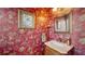 Stylish powder room with decorative wallpaper, a framed mirror, and a charming vanity at 525 Cheval Dr, Venice, FL 34292