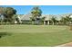 Well-manicured putting green with flags, surrounded by beautiful landscaping and a picturesque building at 525 Cheval Dr, Venice, FL 34292