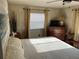 Well-lit bedroom with a window, dresser, and white bedding at 533 Cervina N Dr # 773, Venice, FL 34285