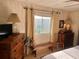 Cozy bedroom featuring wood paneling, matching dressers, and natural light from the window at 533 Cervina N Dr # 773, Venice, FL 34285