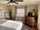 Bright bedroom featuring wood-look walls, a ceiling fan, and a television on a dresser at 533 Cervina N Dr # 773, Venice, FL 34285